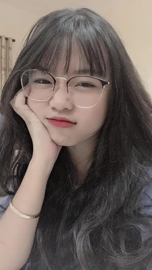 10 Giữa khung hình cận mặt, cô nàng tóc mái đeo kính trong chống tay lên má cười rất mềm
