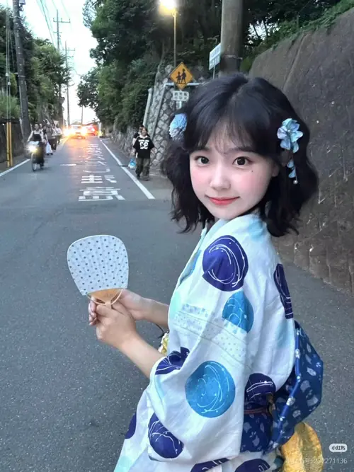 16 Trên con đường yên tĩnh, bạn nữ yukata trắng xanh quay đầu cười, tay cầm quạt tròn