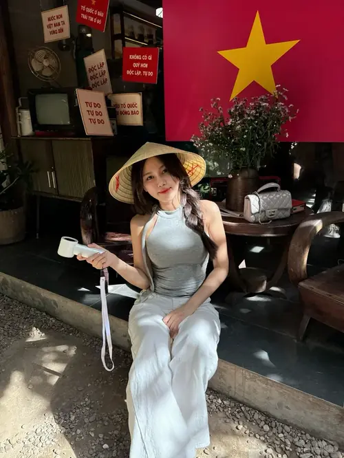 15 Người đẹp Việt mặc áo dài trắng, đứng giữa vườn hoa vàng với khuyên tai tròn lớn