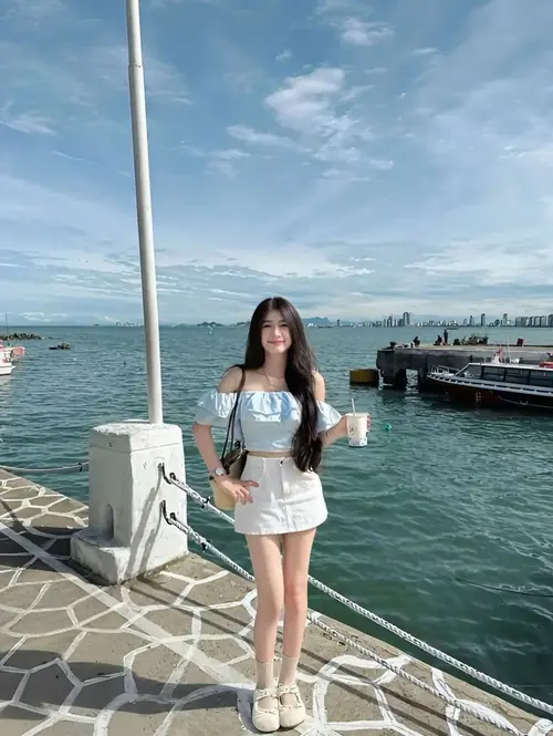12 Trước dãy đèn lồng nhiều màu, cô bé mặc trang phục dân tộc đứng thẳng với mũ len trắng