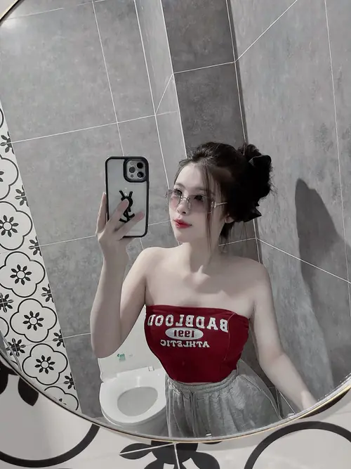 15 Trước gương phòng tắm, cô nàng cá tính buộc tóc cao, mặc áo ống đỏ và chân váy đen