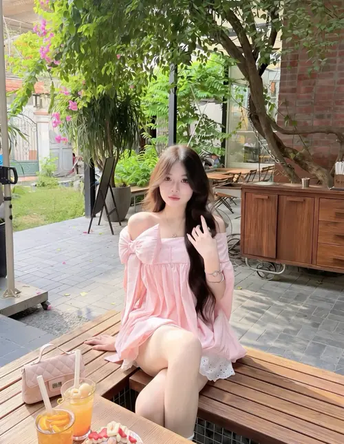 9 Nàng váy hồng ngồi bên bàn nước cam, tóc dài phủ vai và nụ cười rất nhẹ