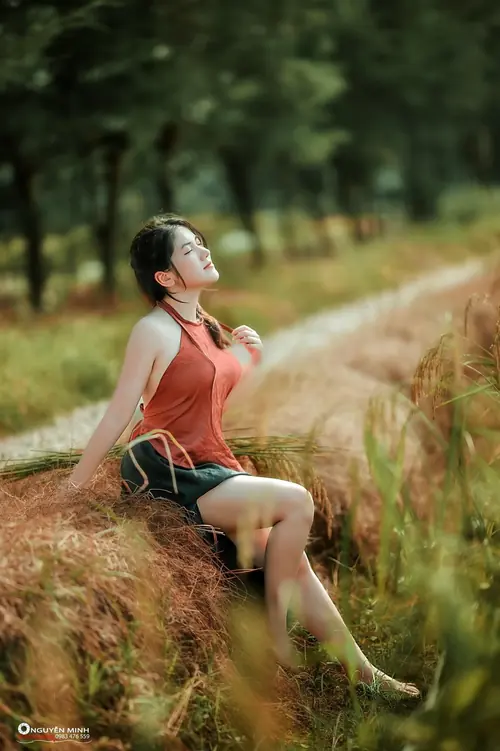 24 Dọc lối cây xanh, một nhan sắc Việt áo cam ngồi trên cỏ, dáng nghiêng thư thái