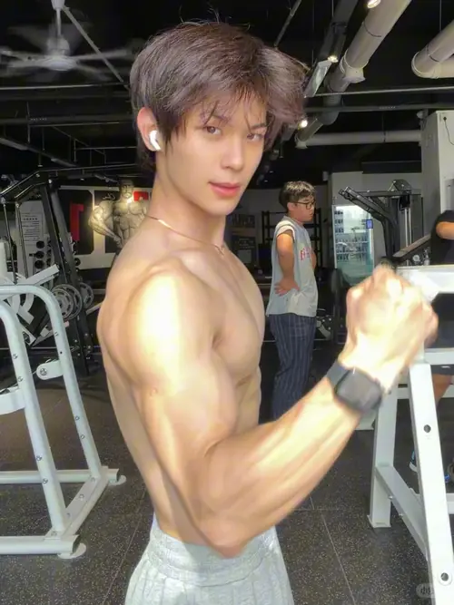 18 Dưới ánh đèn phòng gym, cậu bạn mặc áo sát nách khoe bắp tay rắn chắc khi tạo dáng